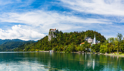 Fototapeta na wymiar スロベニア　ブレッド湖と湖畔に建つ聖マルティヌス教会と崖の上に建つブレッド城