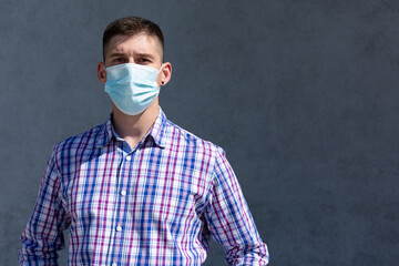 a young man stands with a mask on