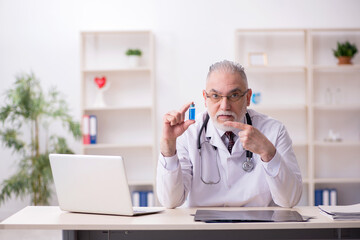Old male doctor working in the clinic