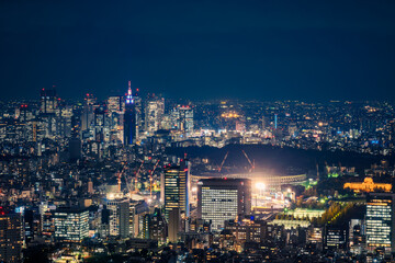 Obraz premium Aerial view from the observation deck at Roppongi Hills Mori Tower in Tokyo at night with the view of Tokyo Olympic Stadium when under construction in 2018 in Japan.