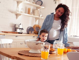 Obraz na płótnie Canvas young pretty african american mother with little cute son on kitchen in morning preparing breakfast, lifestyle people concept