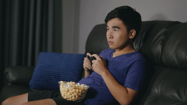 sad young man playing video games and loses at night