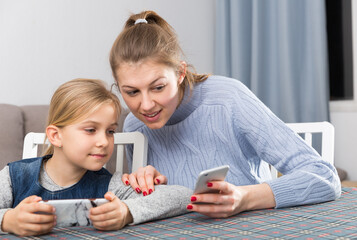Mom and little daughter read a message on the smartphone. High quality photo