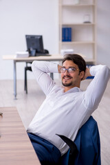 Young male employee and too much work in the office