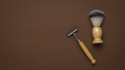 Vintage shaving brush and razor on a brown background. Space for the text.