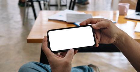 Cropped shot view of man hands holding smart phone with blank copy space screen for your text...