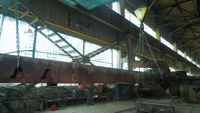 A hoist or crane girder lifts the slab at the factory