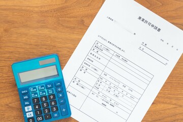 会社の人事部長宛てに作成する兼業許可申請書と金額を計算する電卓