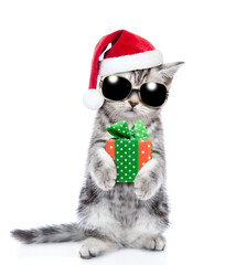 Tabby kitten wearing sunglasses and red christmas hat with gift box. isolated on white background