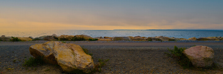 Naklejka premium Two Large glacial rocks over the coastal bikeways with a view of twilight seascape over Martha's Vineyard.