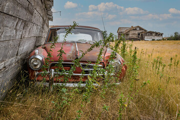 An abandoned car and farmhouse on the Saskatchewan prairies
