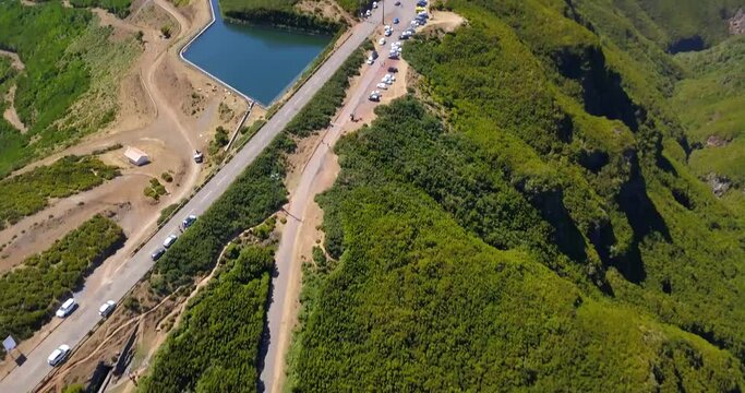 Aerial View Of Vehicles Parked At Parking Lot Near Levada do Alecrim With Mountain Views During Summer In Rabacal, Madeira, Portugal. - tilt up