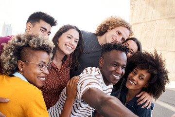 Multiethnic group of friends. Taking selfie outside. Caucasian, Asian, Latino, African American people. Concept joy, having fun, meeting friends.