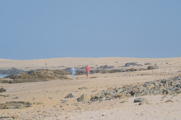 Fototapeta na wymiar People walking along the beach in s distance on the South African shores