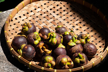 fresh mangosteen on bamboo basketry tray