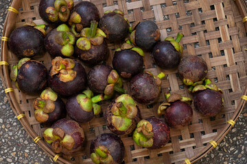 fresh mangosteen on bamboo basketry tray