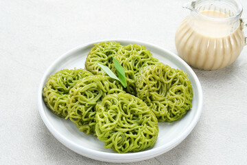 Petulo or Putu Mayang is a traditional Indonesian snack made from strands of rice flour rolled into a ball, colored with pandan or suji leaves, eaten with coconut milk and palm sugar.
