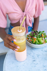A glass for smoothies in the hands of a girl.