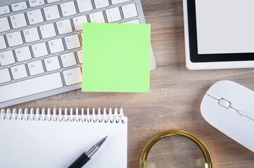 Sticky note with a keyboard and business objects.