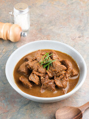Daging Kelem is a traditional food from Central Java, Indonesia, made from beef, coconut milk and spices. It tastes sweet and savory. Served in bowl, close up.
