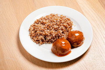 buckwheat with meatballs on the wooden background