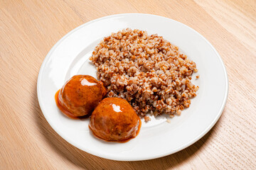 buckwheat with meatballs on the wooden background