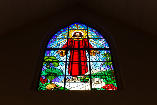 Stained glass window with image of Jesus Christ Ascension among tropical plants and trees motives in St. Paul's Anglican Cathedral, Victoria, Seychelles. 