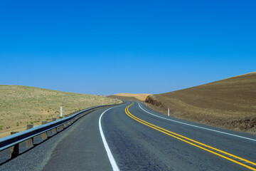 Highway curves through the wheat fields of the Palouse region of