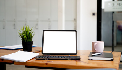 Fototapeta na wymiar Shot of digital tablet with blank white screen, keyboard, cup of coffee on workspace desk