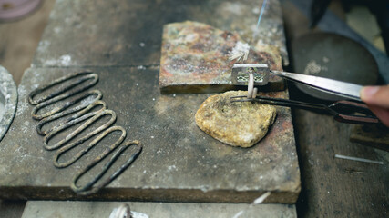Jeweler at work in jewelry. Desktop for craft jewelry making with professional tools. Close up view of tools. Silver jewelry. 