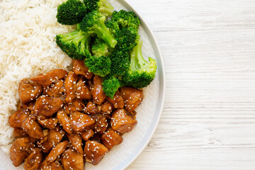 Homemade Teriyaki Chicken with Rice and Broccoli on a plate on a white wooden background, top view. Flat lay, overhead, from above. Space for text.