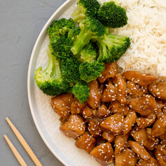 Homemade Teriyaki Chicken with Rice and Broccoli on a plate on a gray surface, top view. Flat lay, overhead, from above.