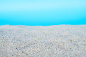 Sea beach sand texture on blue background with Selective focus. Summer background concept. 