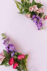 Frame made of beautiful flowers on pink background. Flatlay, top view. View from above. Copy space mockup.