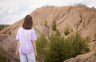 The girl stands in front of the mountain close-up. Travel and rest.