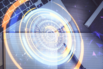 Technology hologram drawing over computer on the desktop background. Top view. Double exposure. Tech concept.