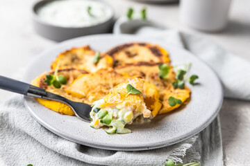 Fried patisson or yellow zucchini with sauce and micro greens, grey concrete background.