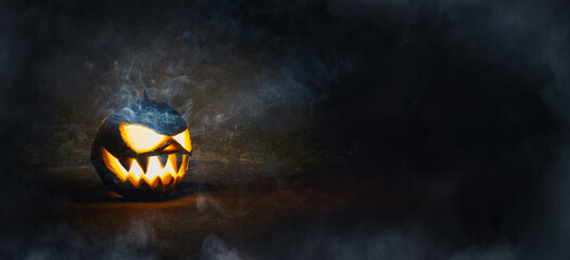 Halloween Pumpkin Smiling Seeing Teeth with Smoke on Dark and Scary Background. Halloween Pumpkin...