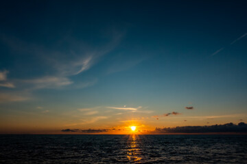 Naklejka premium Sunset by the sea. Gentle waves, a view of the calm sea. Made in climatic lighting conditions.