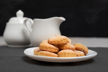Plate with shortcake on teapot and jug background. Homemade shortbread cookies. Baking for tea