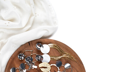 Trendy stylish bijouterie set on white cloth and wooden display. Jewelry with pearl isolated on white