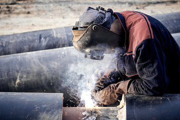 Fototapeta na wymiar Construction worker arc welding the metal pipe.