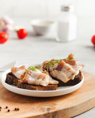 Two bread slices with salted pork bacon or lard, traditional snacks to Ukrainian borscht