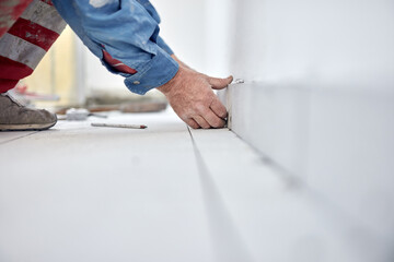 Ceramics tile man worker placing new tiles on the floor and wall.