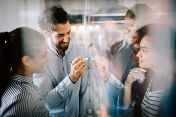 Working together on project. Happy young business colleagues working in office