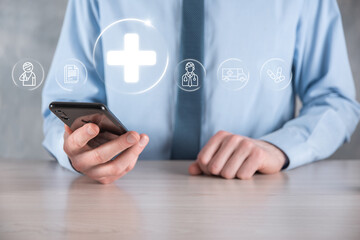 Businessman hold virtual plus medical network connection icons. Covid-19 pandemic develop people awareness and spread attention on their healthcare.Doctor,document,medicine,ambulance,patient icon.