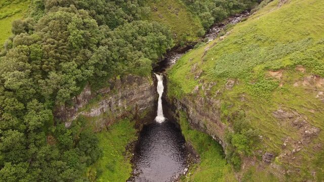 water fall shot from a drone view backing into the the trees