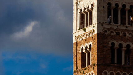 Lucca Cathedral old medieval bell tower exterior (with clouds and copy space) - obrazy, fototapety, plakaty