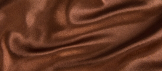 brown or chocolate silk satin fabric texture background.Cloth soft wave. Creases of satin
