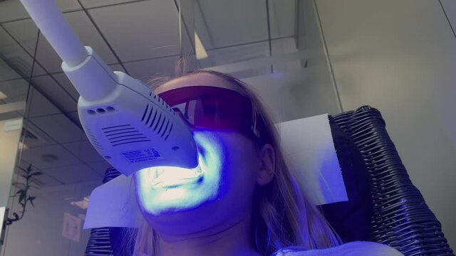 Woman getting her teeth whitened at the dental clinic